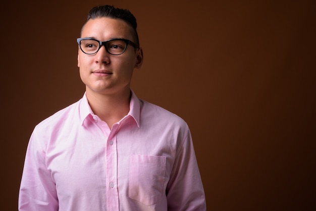 Young handsome multi-ethnic businessman on brown