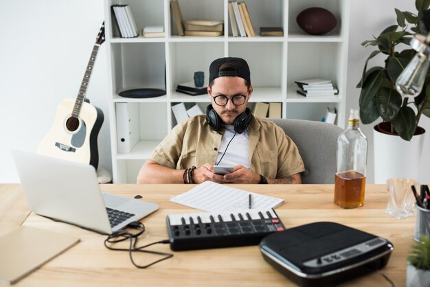 young handsome musician using smartphone at workplace