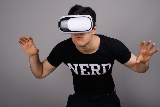 Young handsome nerd man wearing virtual reality headset