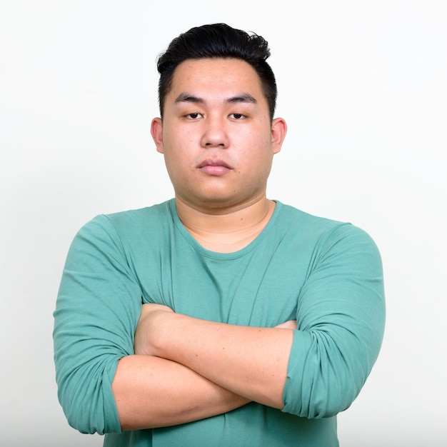  young handsome overweight Filipino man against white wall