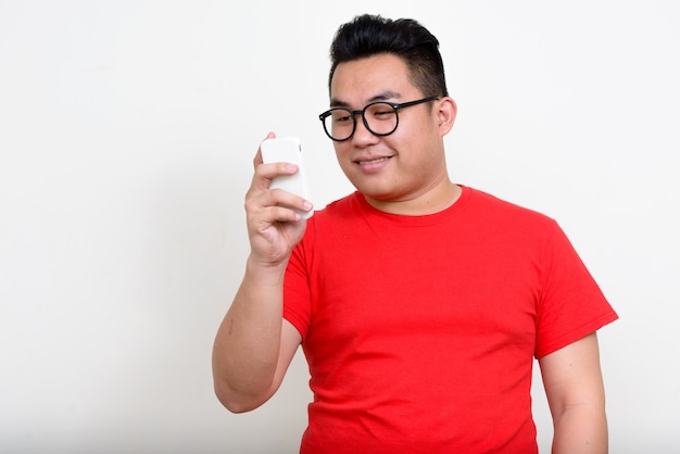  young handsome overweight Filipino man against white wall