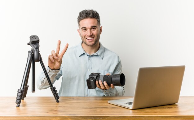 Young handsome photography teacher showing number two with fingers.