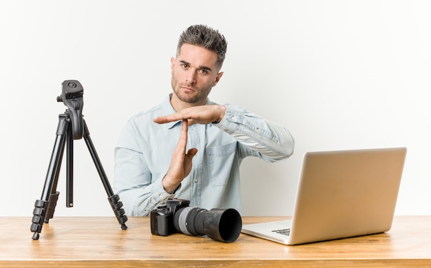 Young handsome photography teacher showing a timeout gesture.