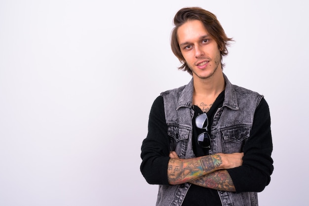  young handsome rebellious man wearing stylish clothes against white wall