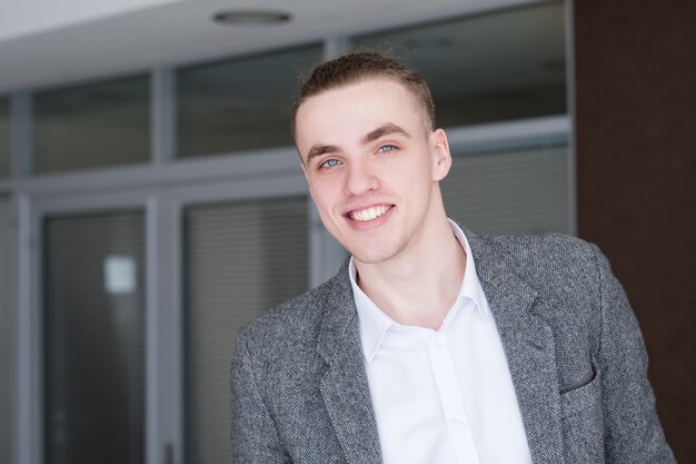 Young handsome smiling business man.