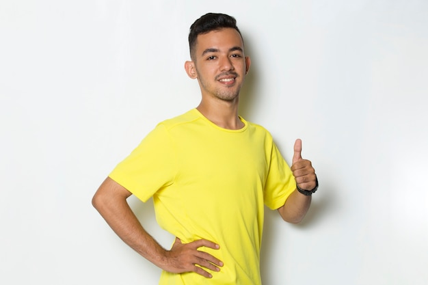 Young handsome sport man  showing a thumbs up ok gesture on white background