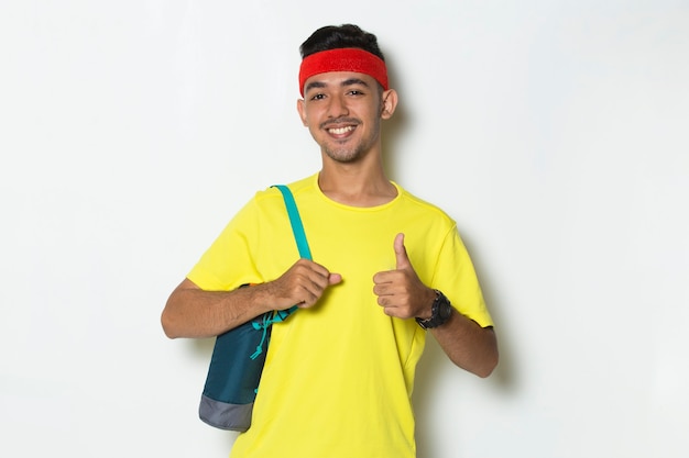 Young handsome sport man  showing a thumbs up ok gesture on white background