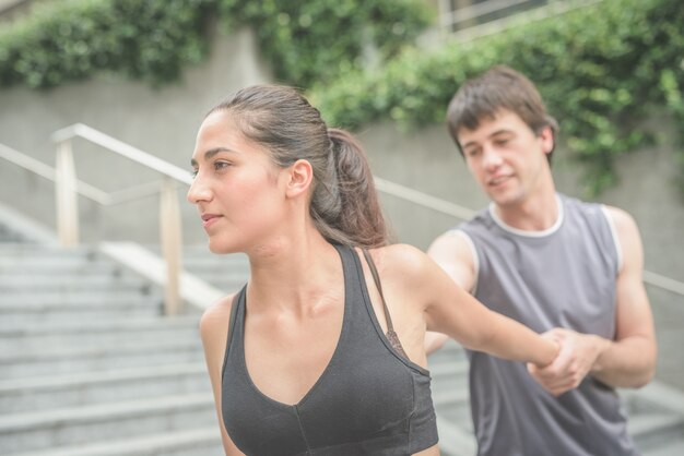 young handsome sportive man and woman stretching