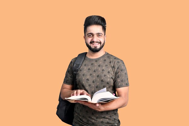 Young handsome student wearing t shirt holding book smiling indian pakistani model