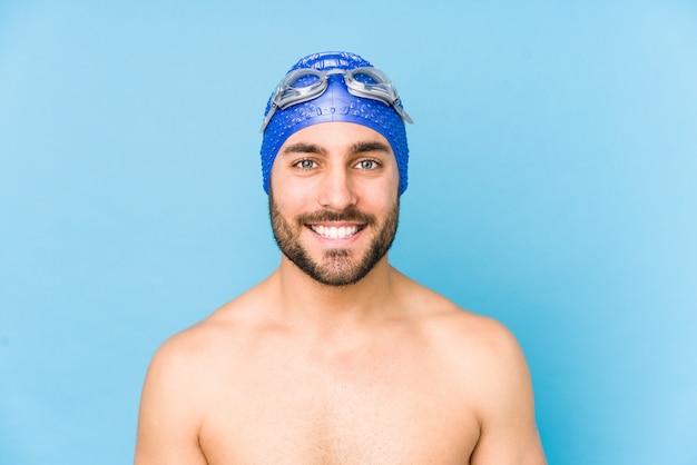 Young handsome swimmer man happy, smiling and cheerful.