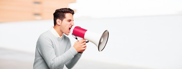 Photo young handsome tanned man with a megaphone