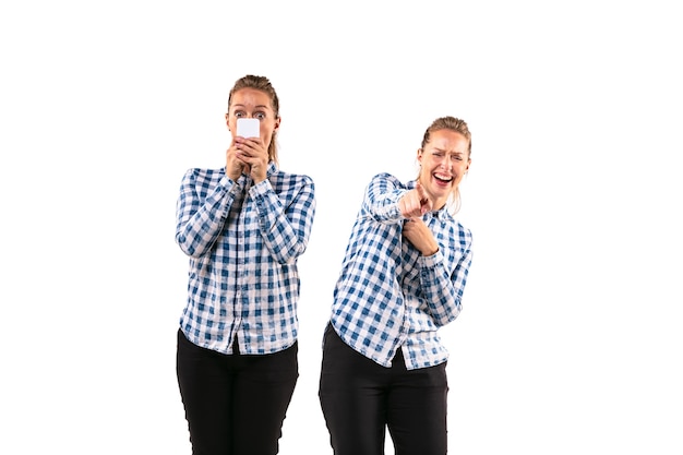 Young handsome woman arguing with herself on white studio background