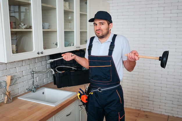 young handyman stand in kitchen at sink