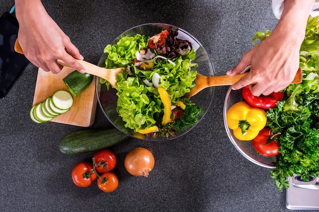 young happiness woman cooking vegetables salad in the kitchen
