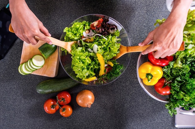 Young happiness Woman Cooking vegetables salad in the kitchen