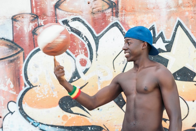 Молодой счастливый африканец играет с баскетбольным мячом