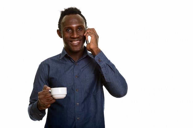 Giovane uomo africano felice che sorride mentre parlando sul telefono cellulare