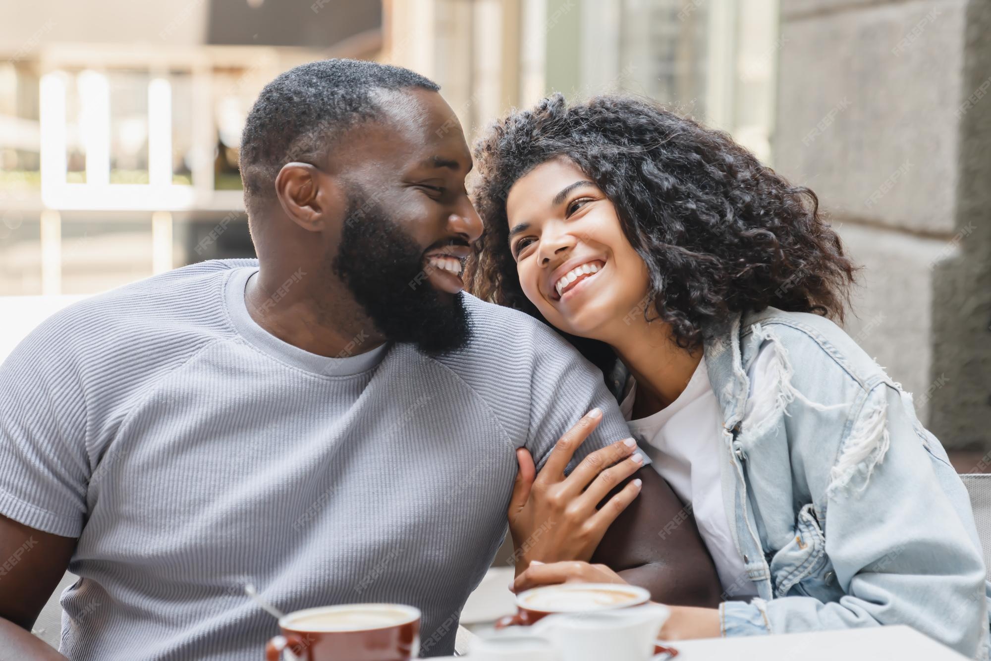 Premium Photo | Young happy africanamerican couple spouses talking together while drinking coffee