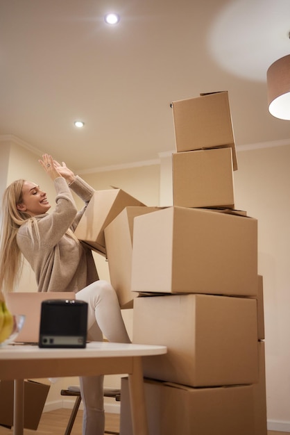 Young happy American woman with stack of cardboard boxes