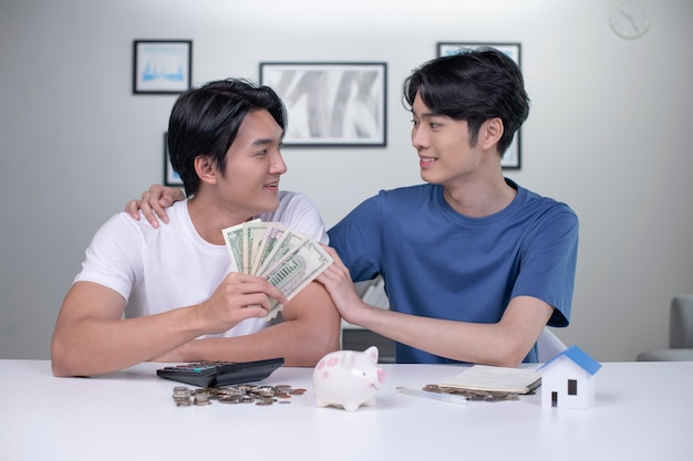 Young happy Asian gay couple saving money to buy a house LGBT men couple saving money for family and home