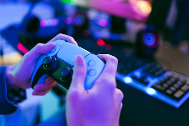 young happy asian man focus on hand holding and pressing buttons of a wireless controller