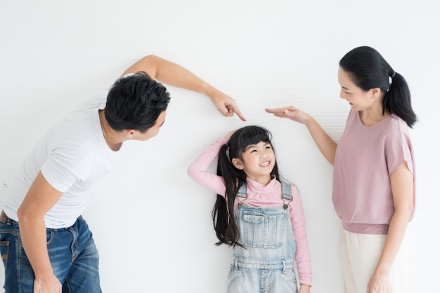 写真 スタジオで娘と遊ぶ若い幸せなアジアの両親