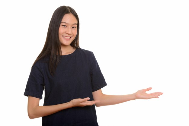 Young happy Asian teenage girl smiling and showing something