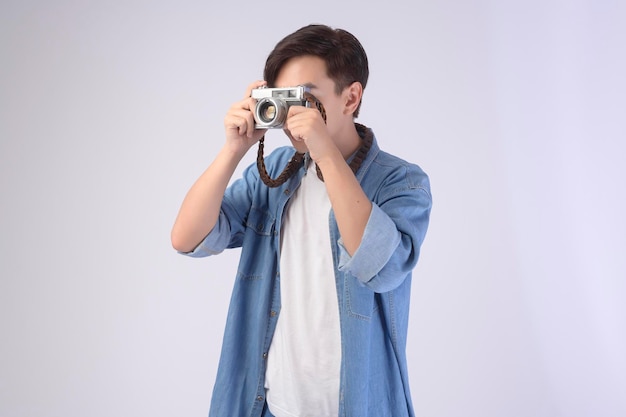 Young happy asian tourist man over white background studio travel and holidays concept