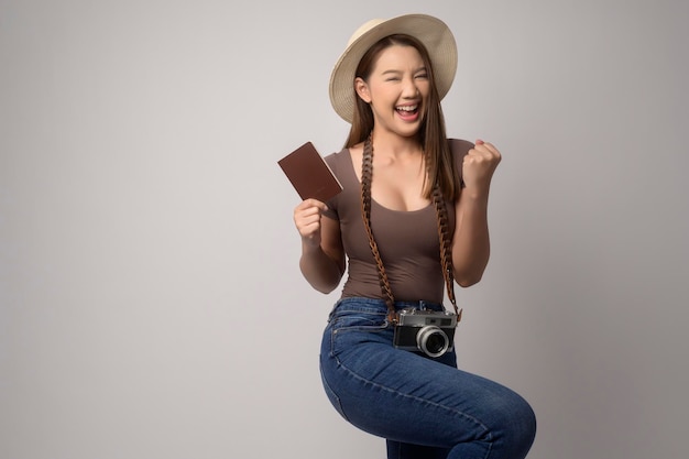 白い背景のスタジオ旅行や休日の概念上の若い幸せなアジア観光女性