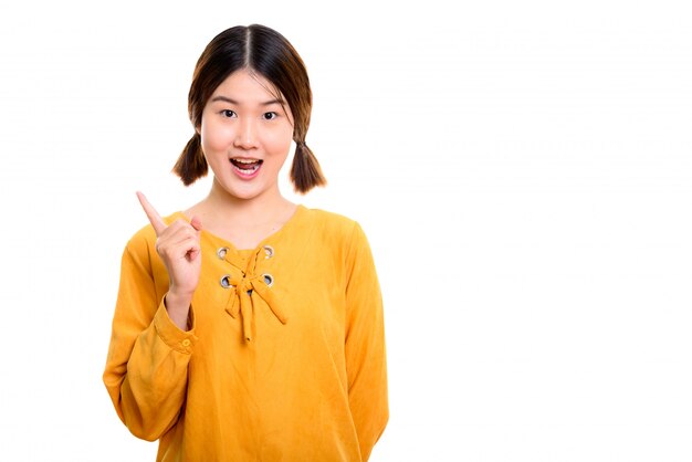 young happy Asian woman smiling while pointing finger up