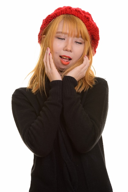 Young happy Asian woman smiling with closed eyes while touching