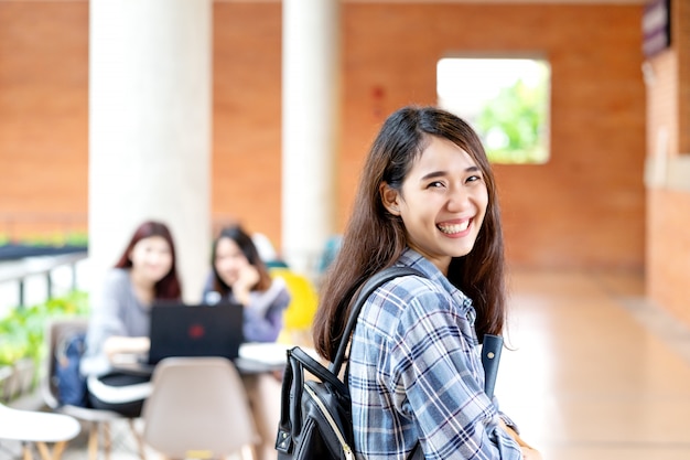 Foto giovane studente asiatico attraente felice che sorride alla macchina fotografica