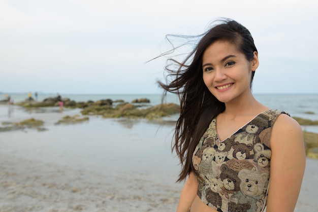 Young happy beautiful Asian woman smiling