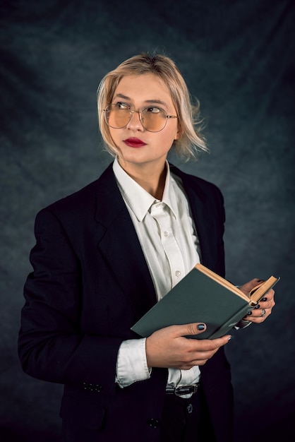 Young and happy beautiful business lady posing in new studio isolated on dark backgrounds