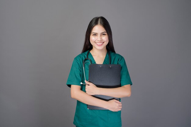 Young happy beautiful woman doctor wearing a green scrubs is holding documents