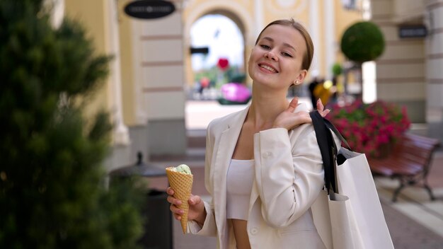 Photo young happy beautiful woman elegant girl is shopping in the outdoors mall holding bags in hand