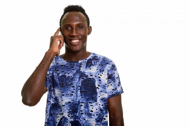 Молодой счастливый черный африканский человек улыбается во время разговора по мобильному телефону