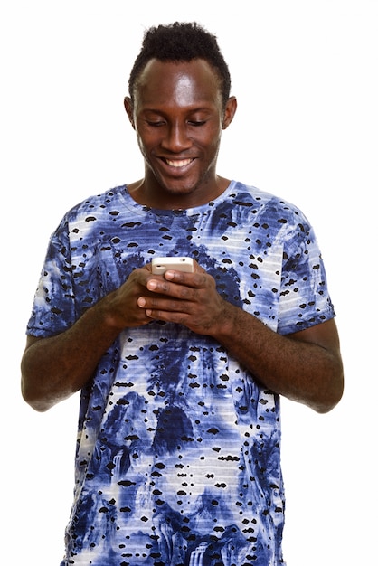 Young happy black African man smiling while using mobile phone