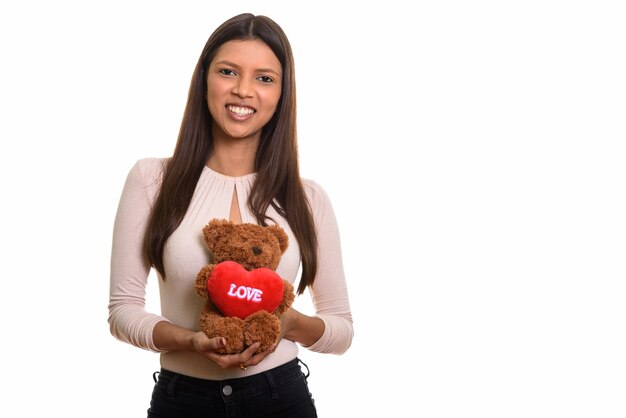 Young happy Brazilian woman smiling while holding teddy bear