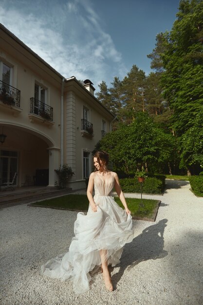 Young happy bride in fashionable lace wedding dress running for the wedding ceremony