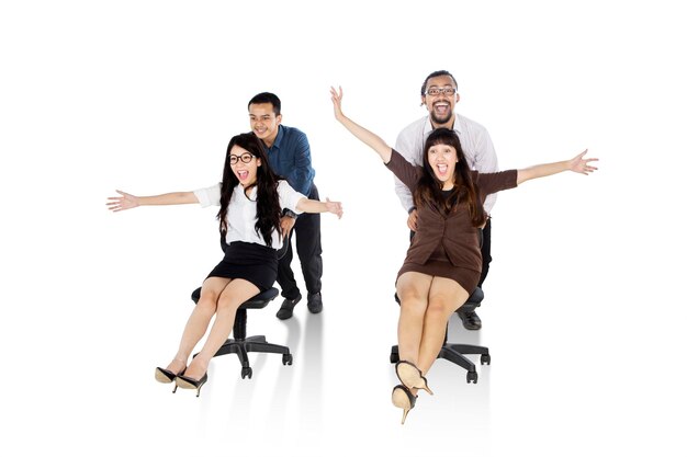 Photo young happy business team riding on chairs