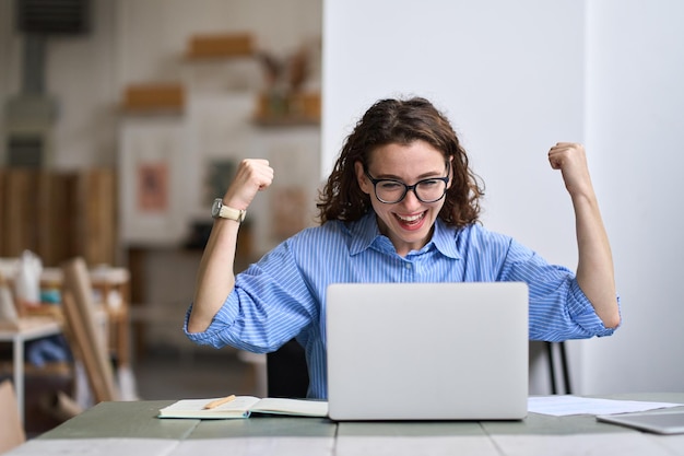 Photo young happy business woman student feels excited wins online looking at laptop