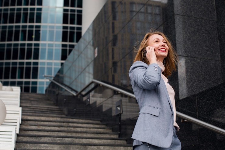 Photo young happy business woman talking on the phone in the of an office building.
