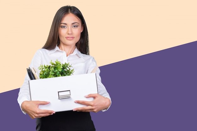 Young happy business woman with a box to move to a new office 