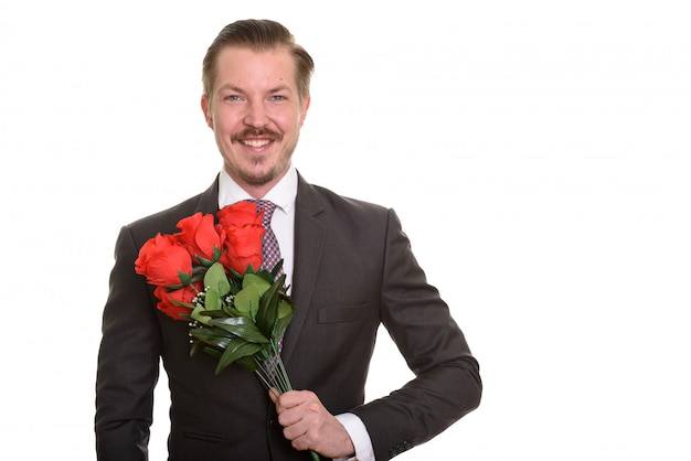 Giovane uomo d'affari felice che giudica le rose rosse pronte per il san valentino