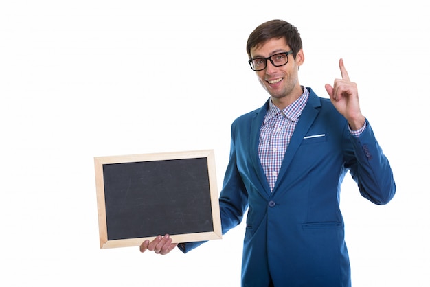 young happy businessman smiling while holding blank blackboard and pointing finger up