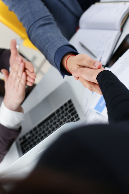 Young happy businessmen have meeting in office shake hands with each other