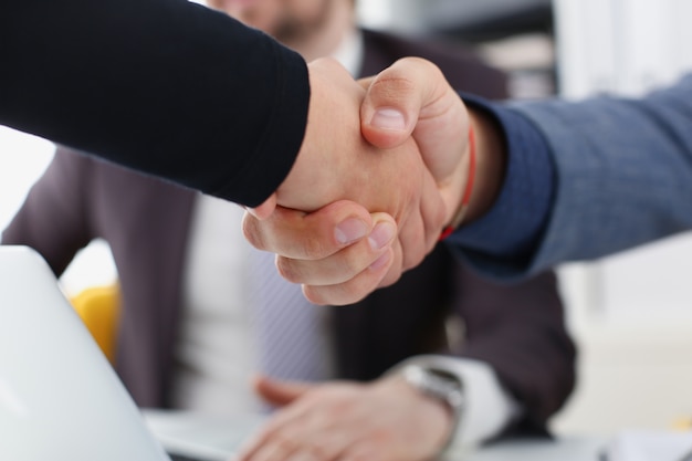 young happy businessmen have meeting in office shake hands with each other