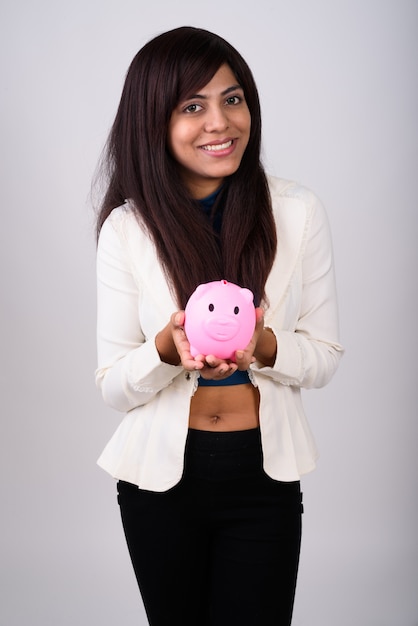 Young happy businesswoman smiling while holding piggy bank ready for investment and saving money