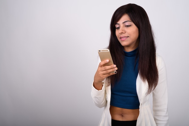 Young happy businesswoman smiling while using mobile phone